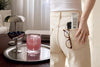 Glow State by UMII, the daily wellness sachet with sixty active ingredients, mixed into a pink drink on a steel tray and carried in a back pocket beside a phone.